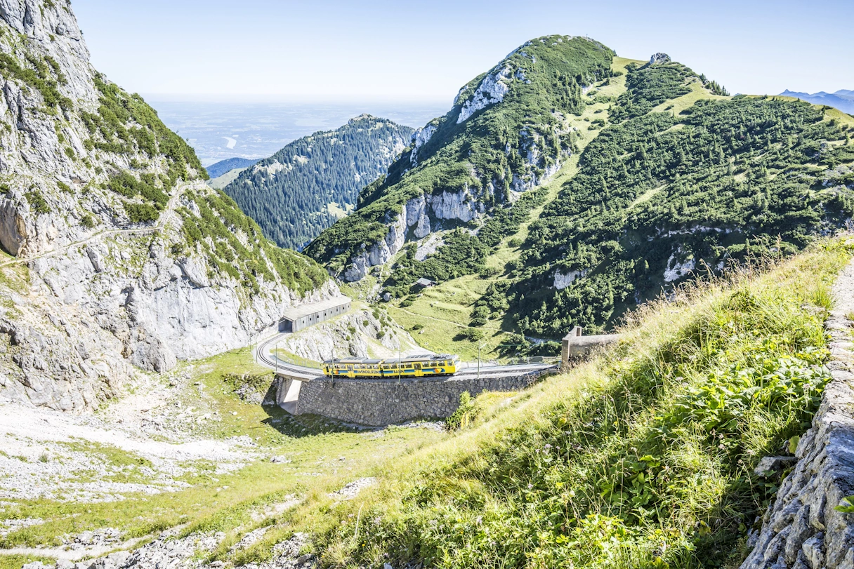 Wendelstein Zahnradbahn im Sommer bei gutem Wetter, umgeben von Bergen