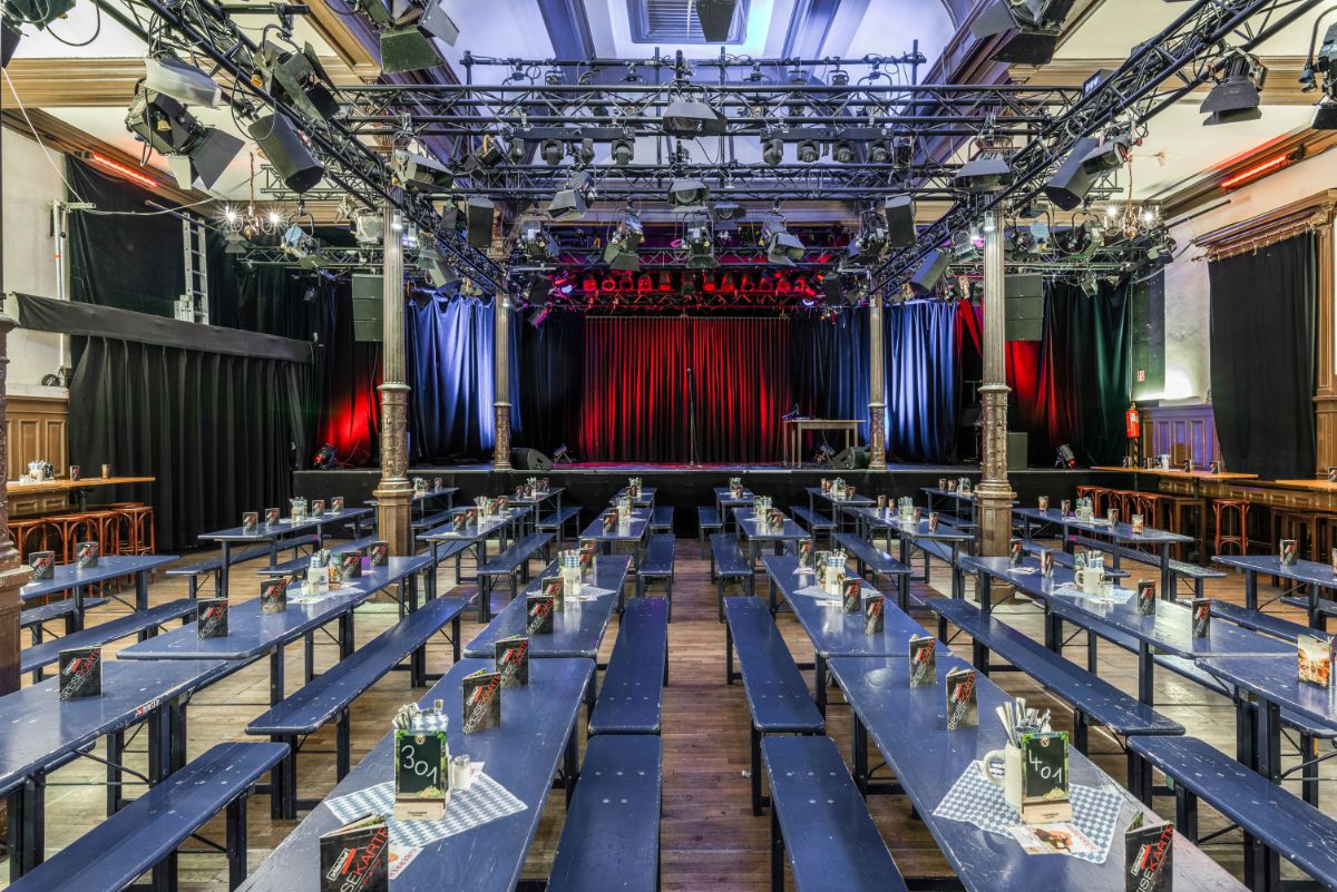 Wirtshaus im Schlachthof, Munich, long tables and beer benches, view of the stage